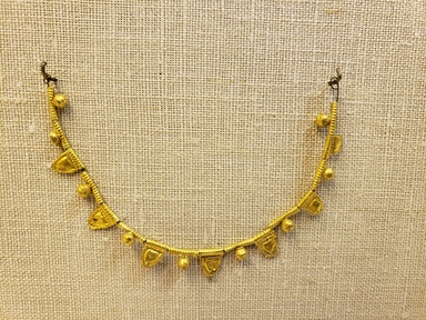 Greek. <em>Bead with Ribbed Tube and Flag</em>, late 4th century B.C.E. Gold, Tube: 1/4 in. (0.7 cm). Brooklyn Museum, Gift of Mr. and Mrs. Thomas S. Brush, 71.79.40. Creative Commons-BY (Photo: Brooklyn Museum, CUR.71.79.40-.55_overall01.jpg)