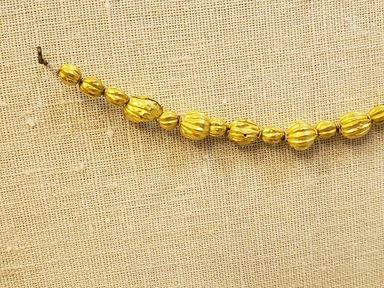 Greek. <em>Melon Shaped Bead Pierced Lengthwised with Beaded Rim</em>, late 4th century B.C.E. Gold, 3/16 x 3/8 in. (0.5 x 1 cm). Brooklyn Museum, Gift of Mr. and Mrs. Thomas S. Brush, 71.79.56. Creative Commons-BY (Photo: Brooklyn Museum, CUR.71.79.56-.76_detail01.jpg)