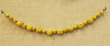 Greek. <em>Melon Shaped Bead Pierced Lengthwised with Beaded Rim</em>, late 4th century B.C.E. Gold, 1/4 x 3/8 in. (0.7 x 0.9 cm). Brooklyn Museum, Gift of Mr. and Mrs. Thomas S. Brush, 71.79.57. Creative Commons-BY (Photo: Brooklyn Museum, CUR.71.79.56-.76_overall.jpg)
