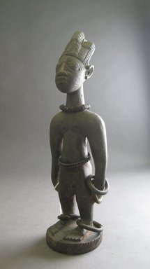 Yorùbá artist. <em>Male twin figure (Ère Ìbejì)</em>, late 19th or early 20th century. Wood, metal, beadwork, h: 10 1/4 in. (26.0 cm). Brooklyn Museum, Gift of Merton D. Simpson to the Jennie Simpson Educational Collection of African Art, 72.175.7. Creative Commons-BY (Photo: Brooklyn Museum, CUR.72.175.7_overall.jpg)