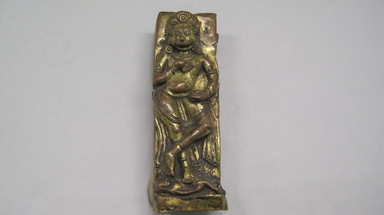  <em>Relief Plaque Depicting a Lion - Headed Deity of Tantric Form</em>, 16th-17th century. Repousse and partially gilded copper mounted on wood, 6 1/2 x 2 1/8 in. (16.5 x 5.4 cm). Brooklyn Museum, Gift of Dr. Bertram H. Schaffner, 73.99.25. Creative Commons-BY (Photo: , CUR.73.99.25.jpg)