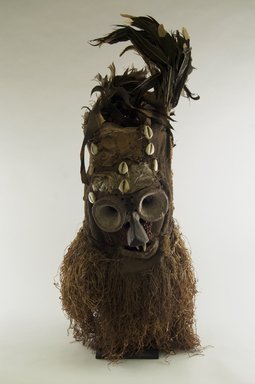 Luntu. <em>Fiber Mask with Conical Eyes (Batwape)</em>, late 19th or early 20th century. Burlap, wood, hide, cotton fiber, feathers, seeds, cowrie shells, pigment, 28 1/2 x 11 x 12 in. (72.4 x 28.0 x 30.5 cm). Brooklyn Museum, Gift of Marcia and John Friede, 74.121.3. Creative Commons-BY (Photo: Brooklyn Museum, CUR.74.121.3_front_PS5.jpg)