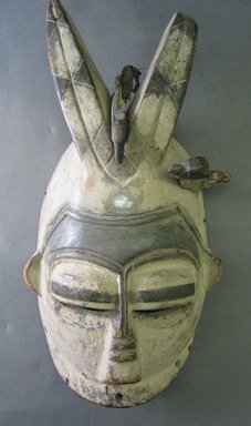 Edo. <em>Ekpo Face Mask with Two Horns and Birds</em>, late 19th or early 20th century. Wood, pigment, glass mirror, metal, 13 x 6 1/4 x 4 in. (33.0 x 15.8 x 10.2 cm). Brooklyn Museum, Gift of Dr. and Mrs. Abbott A. Lippman, 78.178.3. Creative Commons-BY (Photo: Brooklyn Museum, CUR.78.178.3_front.jpg)