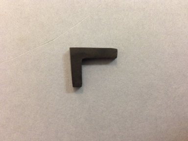  <em>Amulet, T - Square</em>. Hematite, 5/8 × 3/16 × 9/16 in. (1.6 × 0.4 × 1.4 cm). Brooklyn Museum, Brooklyn Museum Collection, X249.38. Creative Commons-BY (Photo: , CUR.X249.38_view01.jpg)