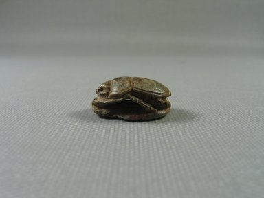  <em>Scarab</em>. Steatite, glaze
, 3/8 x 11/16 x 15/16 in. (1 x 1.8 x 2.4 cm) Measurements: Base 2.4 x 1.8. Height 1.2 cm. Brooklyn Museum, Gift of Evangeline Wilbour Blashfield, Theodora Wilbour, and Victor Wilbour honoring the wishes of their mother, Charlotte Beebe Wilbour, as a memorial to their father, Charles Edwin Wilbour, 16.416. Creative Commons-BY (Photo: Brooklyn Museum, CUR_16.416_view04.jpg)