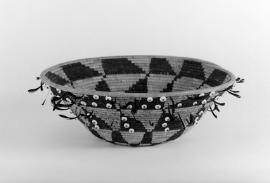 Pomo. <em>Gift or Jewel Basket with black and red feathers</em>, late 19th–early 20th century. Fiber, feather, shell bead, 2 3/4 x 9 1/4 in. (7 x 23.5 cm). Brooklyn Museum, Brooklyn Museum Collection, X719.1. Creative Commons-BY (Photo: Brooklyn Museum, x719.1_bw.jpg)