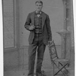 [Untitled] (Gentleman Standing Next to a Vail Folding Chair)