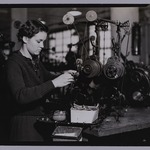 [Untitled]  (Young Woman Standing at Tabletop Thread Machine)