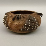 Small Basket decorated with white beads and red and black feathers.