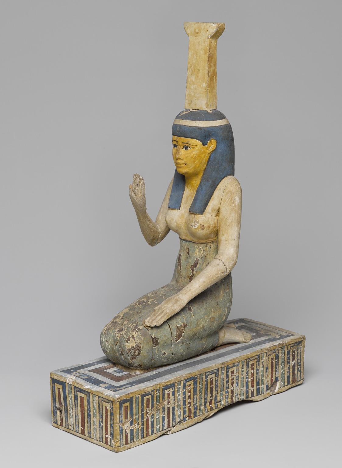 Sitting statue of Nephthys with a tall headdress. 