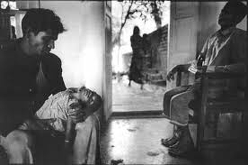 Mary Ellen Mark (American, 1940-2015). <em>Man with Child in Dispensary, Mother Teresa Untitled 39</em>, 1981; printed later. Gelatin silver photograph, Sheet: 15 7/8 × 19 7/8 in. (40.3 × 50.5 cm). Brooklyn Museum, Gift of Howard Greenberg, 2019.50.9. © artist or artist's estate (Photo: Image courtesy of the estate of Mary Ellen Mark, CUR.2019.50.9_MaryEllenMarkEstate_photograph.jpg)